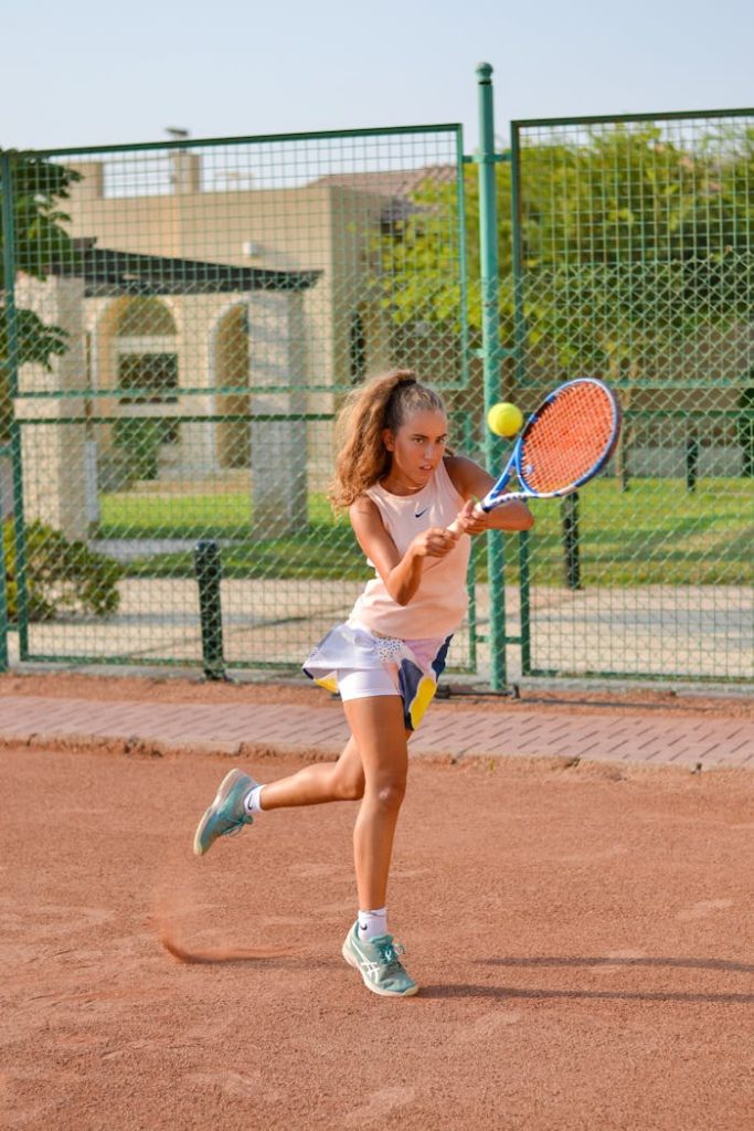 Sporty female playing tennis on court